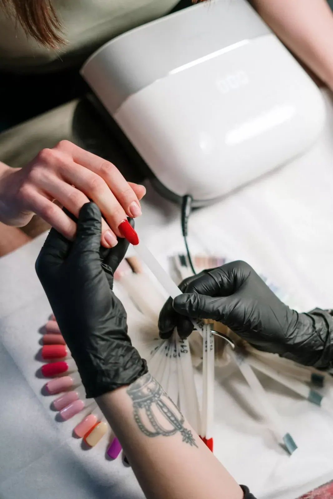 A manicurist painting nails red